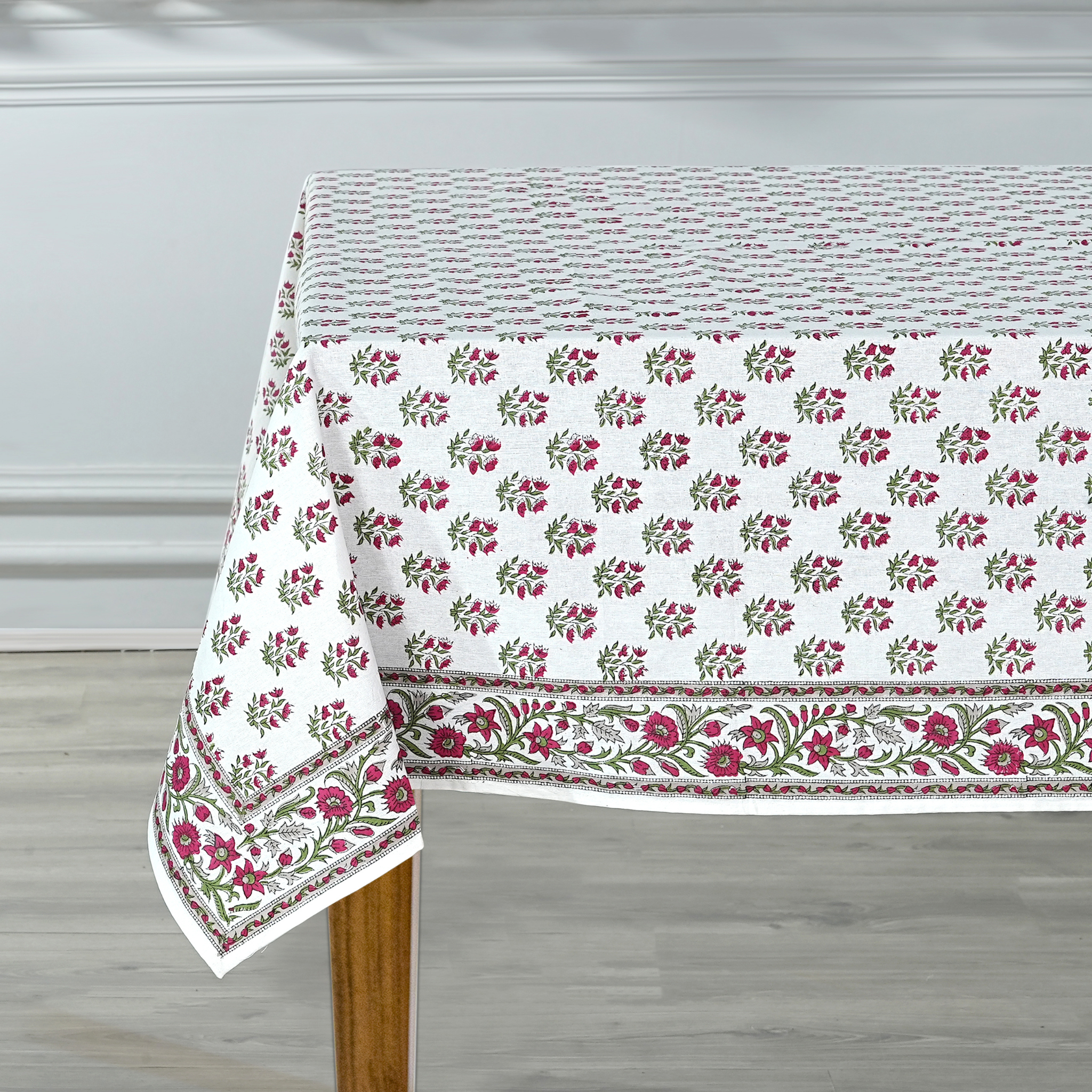 Floral patterned tablecloth on a wooden table with a neutral background