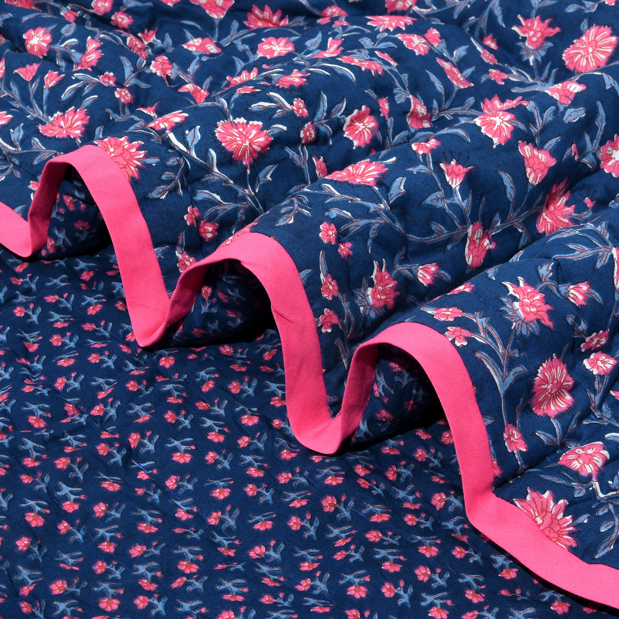 Navy blue fabric with pink floral pattern and pink ruffle trim
