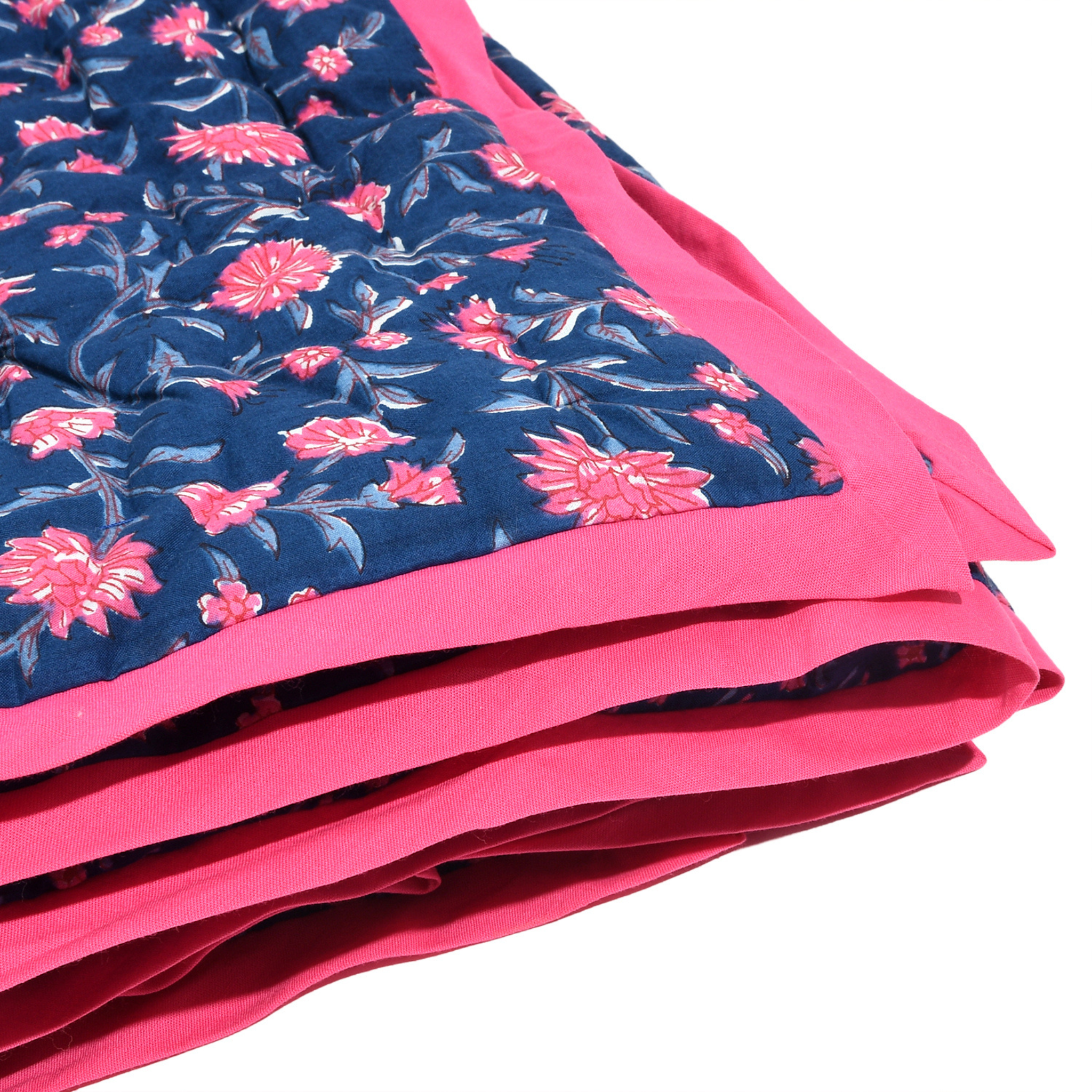 Stack of pink and blue floral fabric with a white background