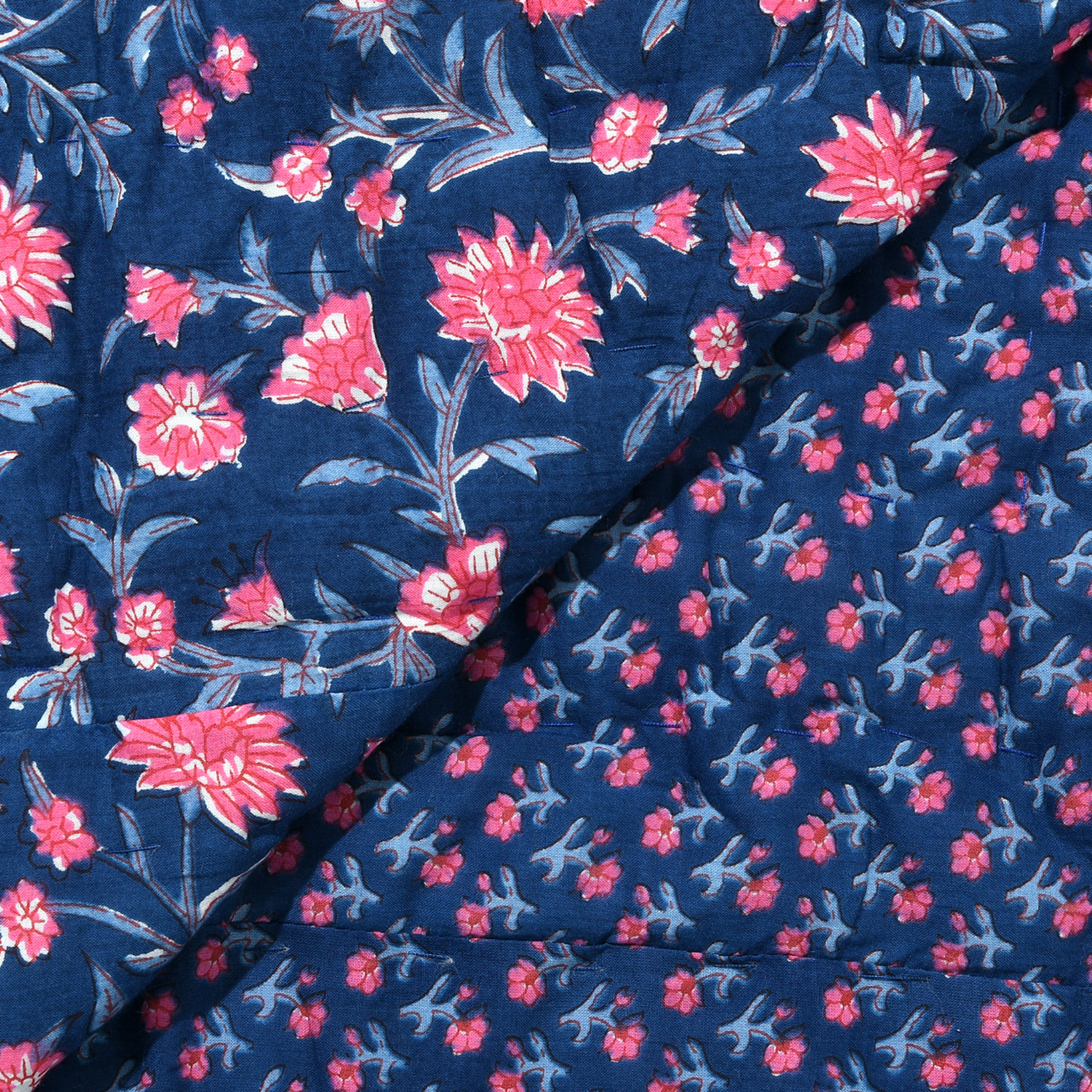 Floral patterned fabric with pink flowers on a blue background