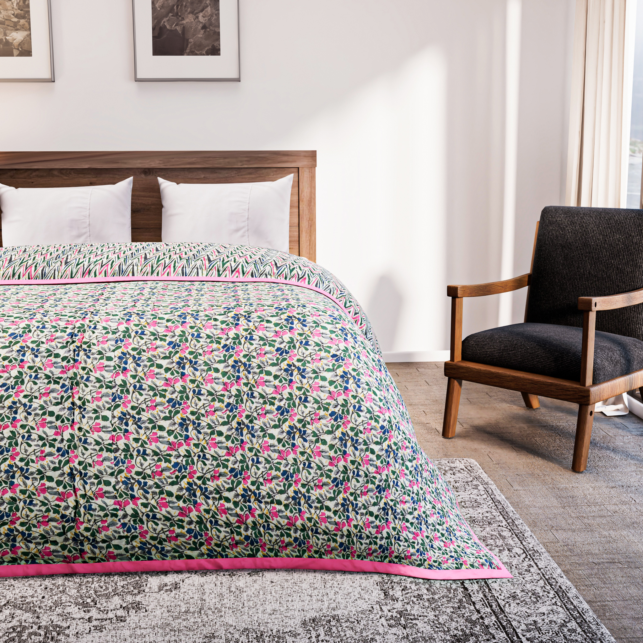 Bed with floral quilt in a bedroom setting with a chair and artwork on the wall.