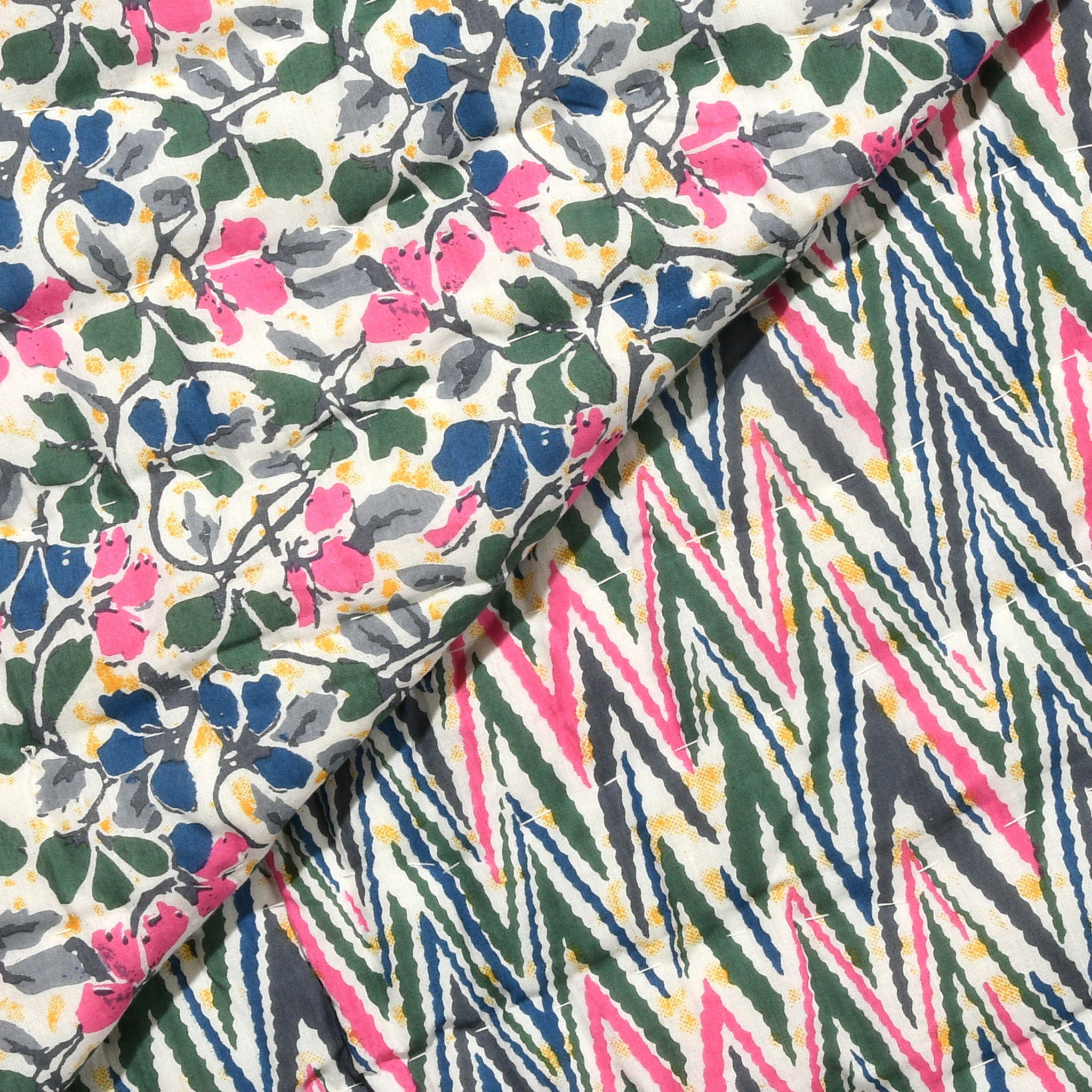 Two pieces of fabric with different patterns, one floral and one geometric, on a white background.