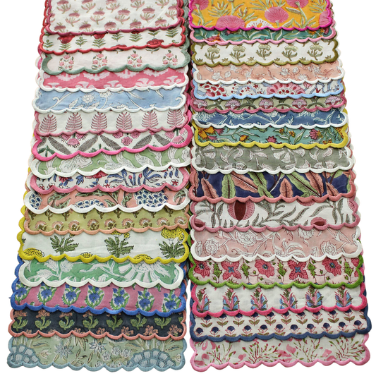 Stack of colorful lace doilies with floral patterns on a white background