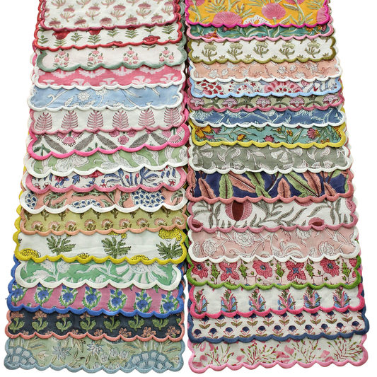 Stack of colorful lace fabric samples with floral and scalloped patterns.