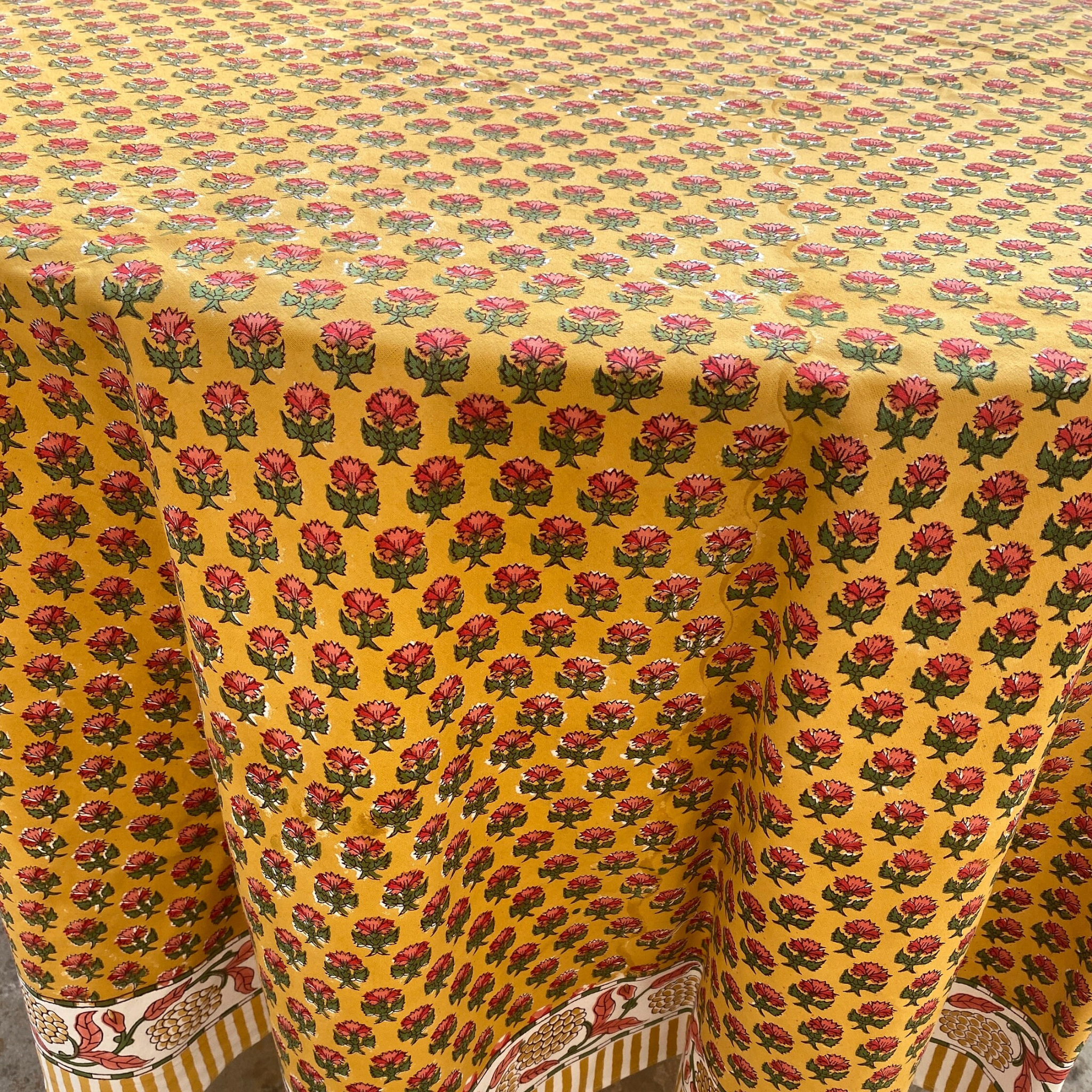 Yellow fabric with red floral pattern, possibly a tablecloth or fabric swatch.