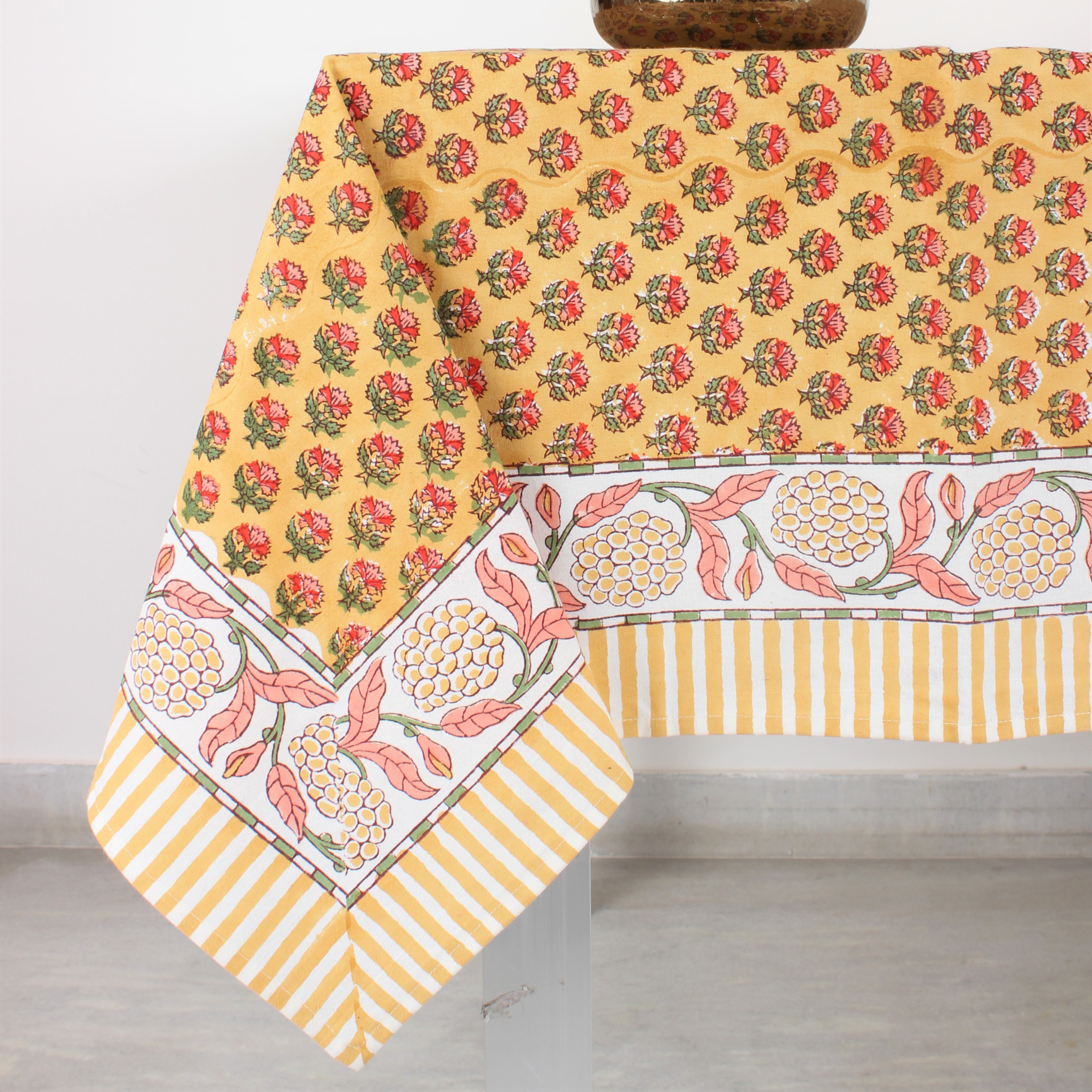 Yellow floral patterned tablecloth on a wooden table