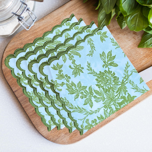Set of green leaf-patterned paper on a wooden board with basil leaves in the background