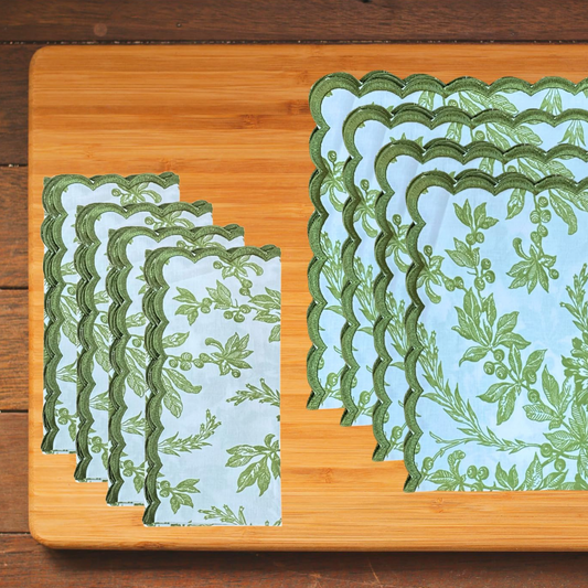 Set of green and white patterned placemats on a wooden cutting board.