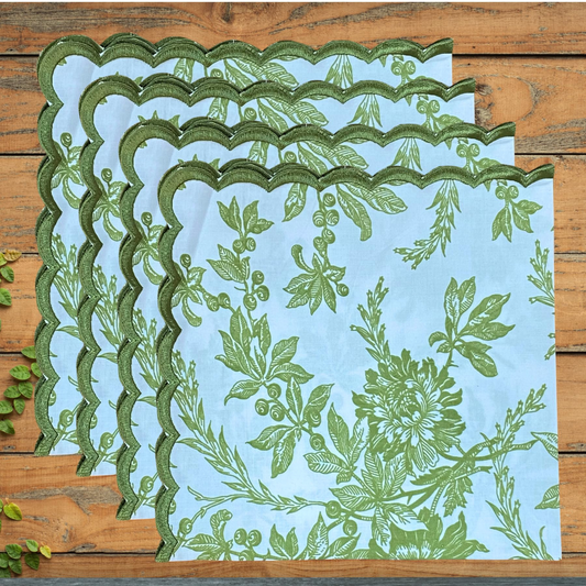 Set of green leaf-patterned placemats on a wooden surface