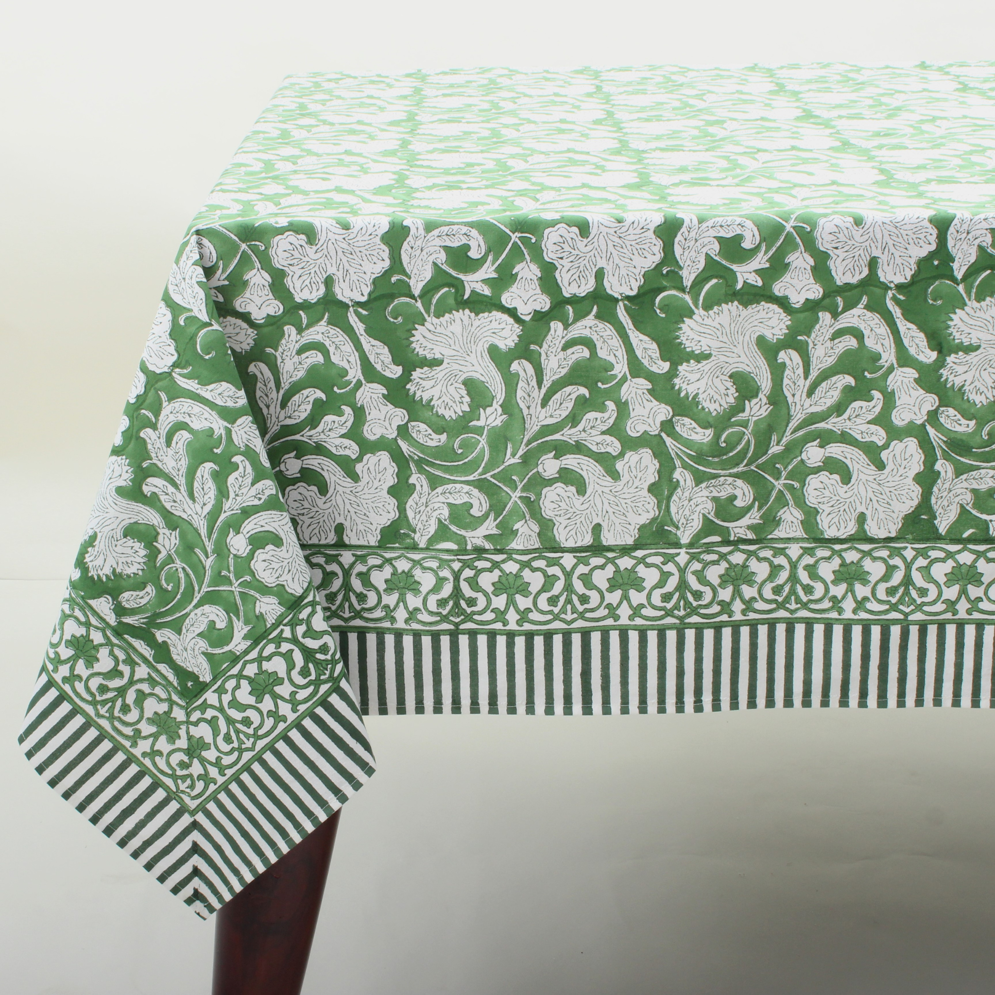 Green and white patterned tablecloth on a table with a plain background