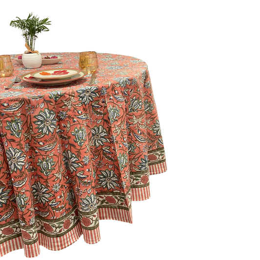 Round table with a floral patterned tablecloth on a white background