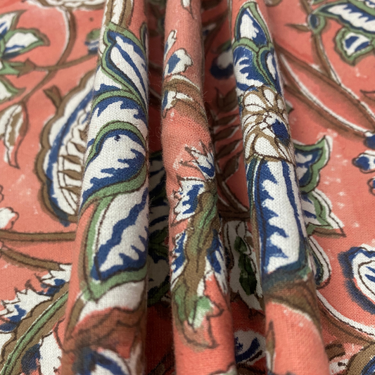 Close-up of patterned fabric with intricate design on a pink background