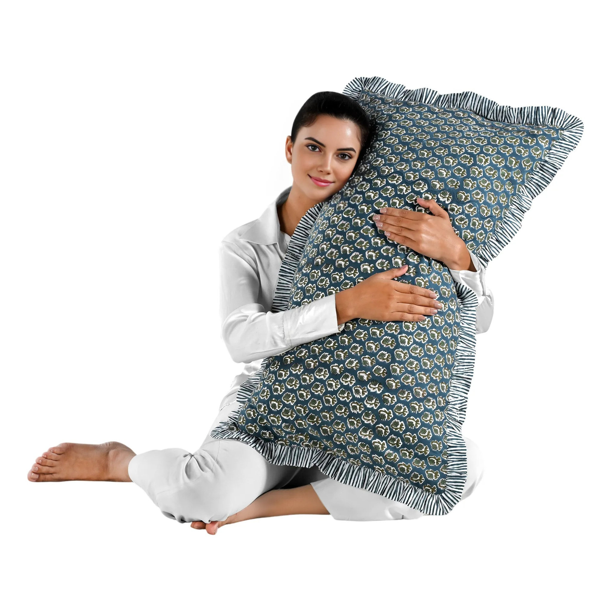 Woman holding a large blue floral block print cotton pillow with green edges.