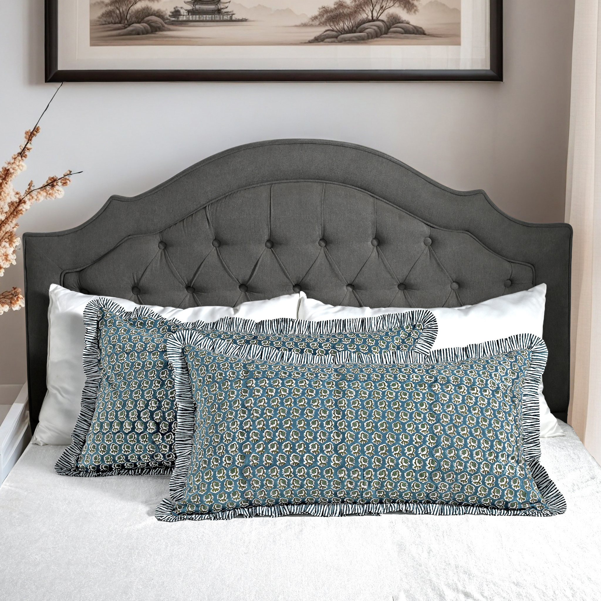 Large block print cotton pillows styled on gray upholstered bed.
