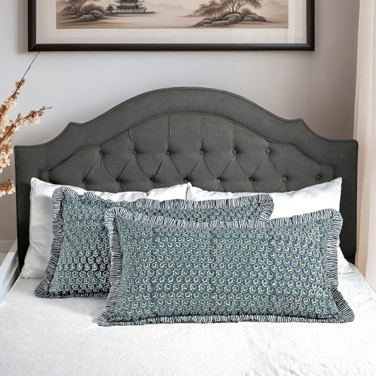Large block print cotton pillows styled on gray upholstered bed.