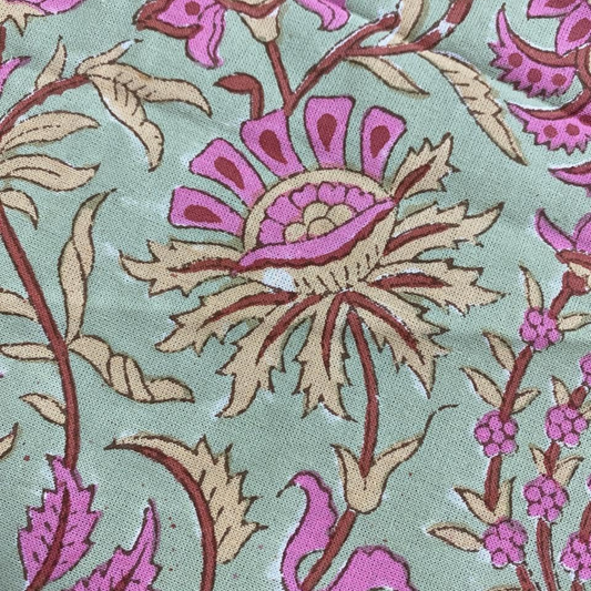 Close-up of floral patterned fabric with pink and beige flowers on a light green background
