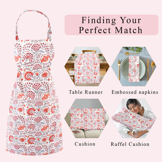 Floral apron with matching table runner, napkins, cushion, and ruffel cushion on a pink background.