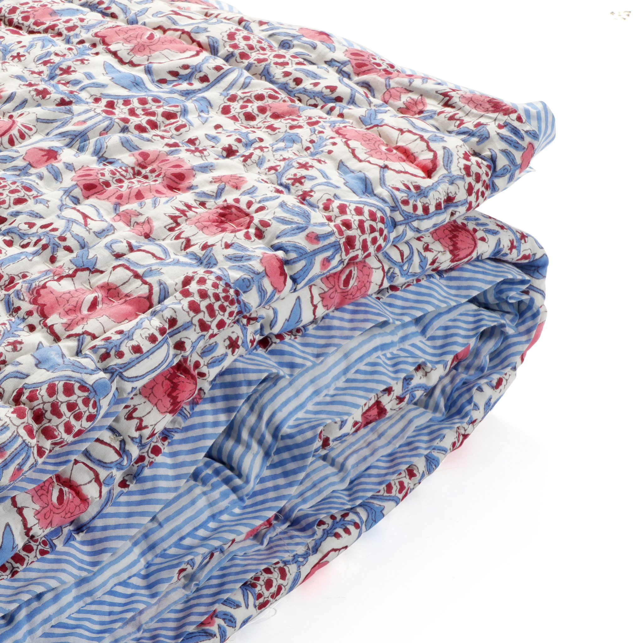 Floral-patterned quilt with pink and blue design on a white background