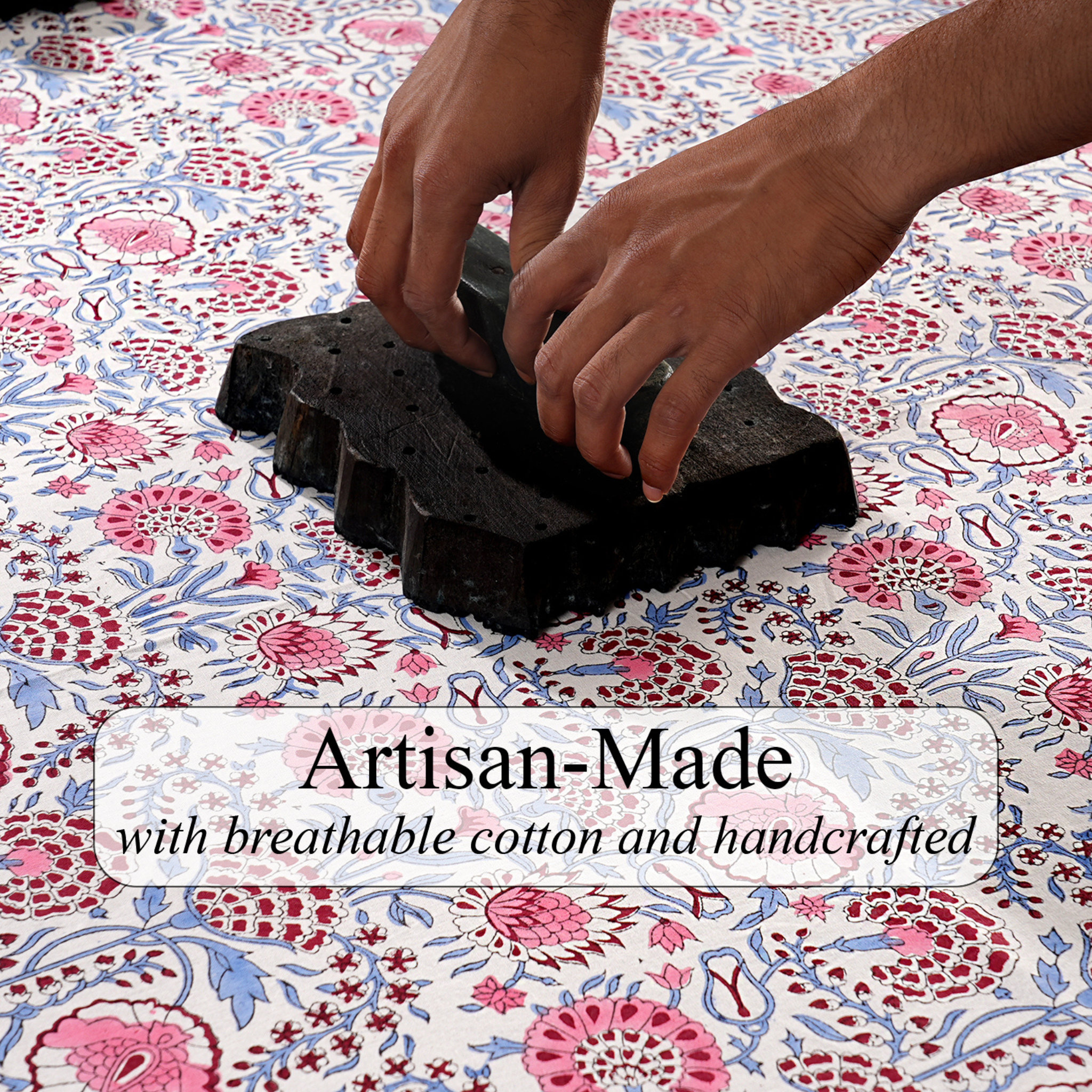Hands working with black material on a floral fabric background, with text 'Artisan-Made with breathable cotton and handcrafted'.