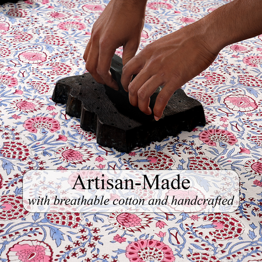 Hands working with black material on a floral fabric background, with text 'Artisan-Made with breathable cotton and handcrafted'.