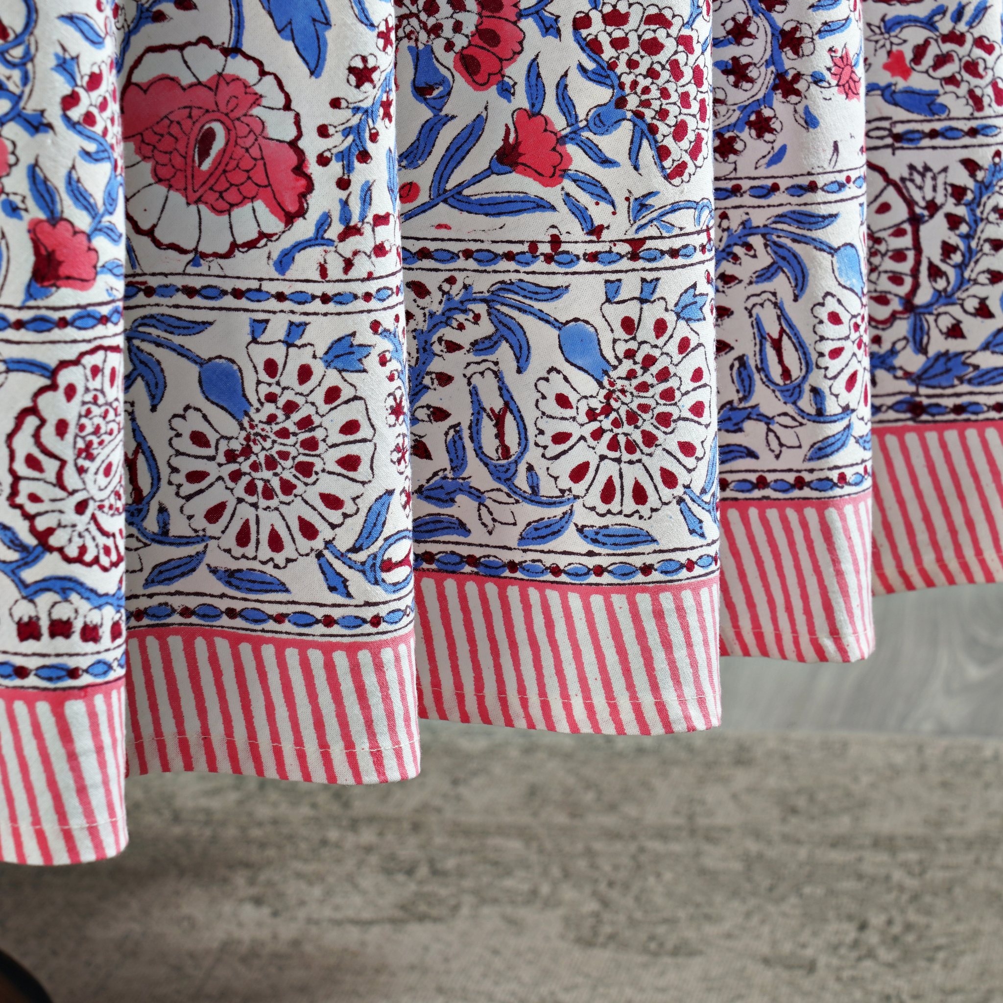 Close-up of a fabric with red, blue, and white patterns on a gray surface