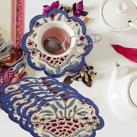 Decorative placemats with floral patterns on a table setting with a teacup and teapot.