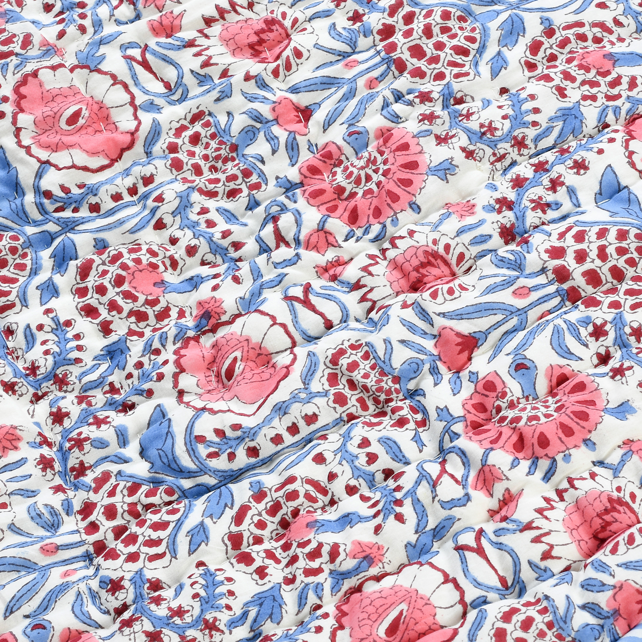 Close-up of floral fabric with pink and blue patterns on a white background