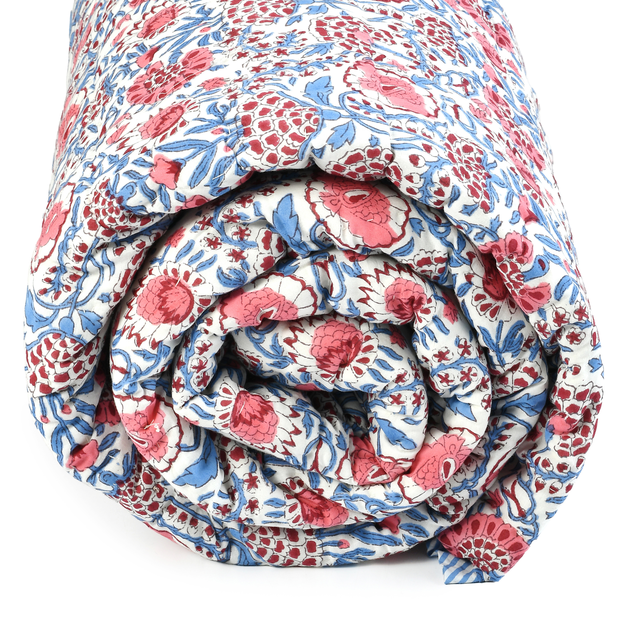 Rolled-up floral quilt with red, blue, and white pattern on a white background