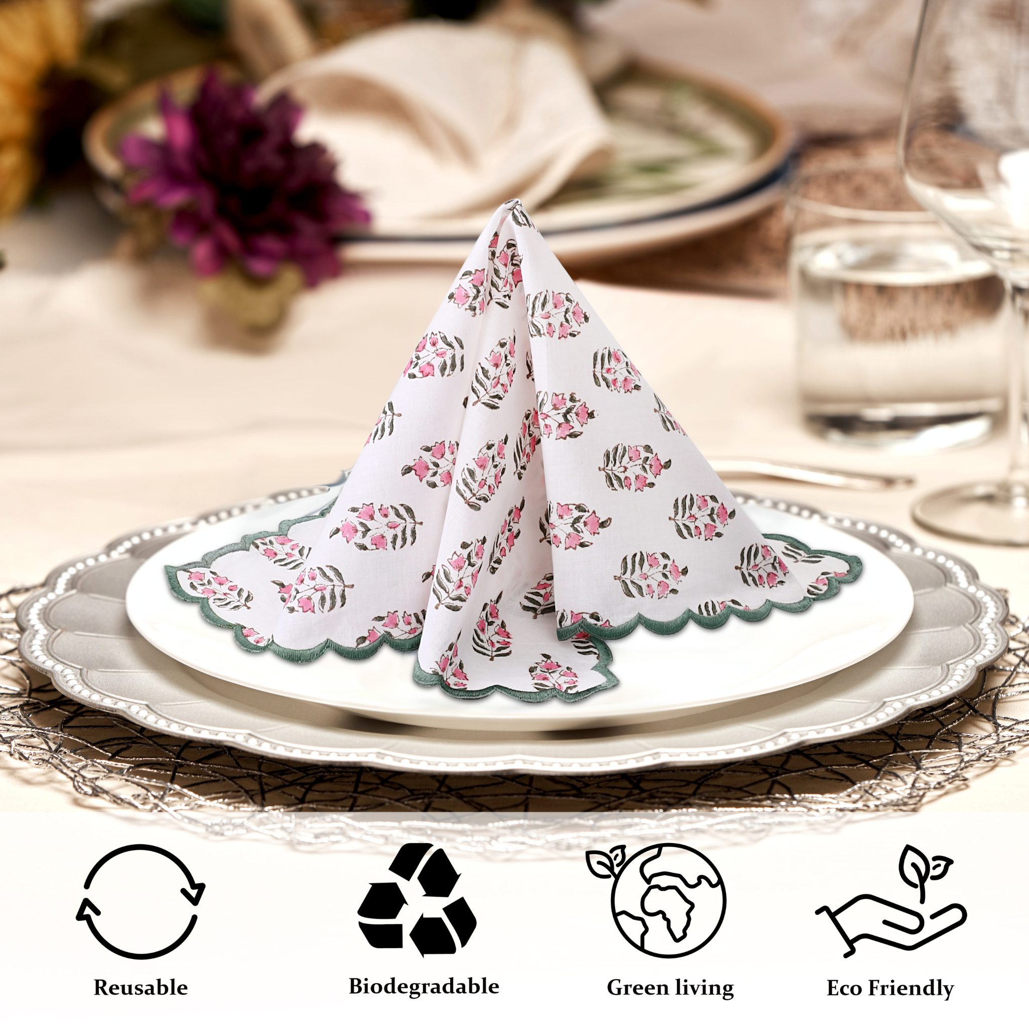 Folded floral napkin on a plate with table setting and eco-friendly icons below.