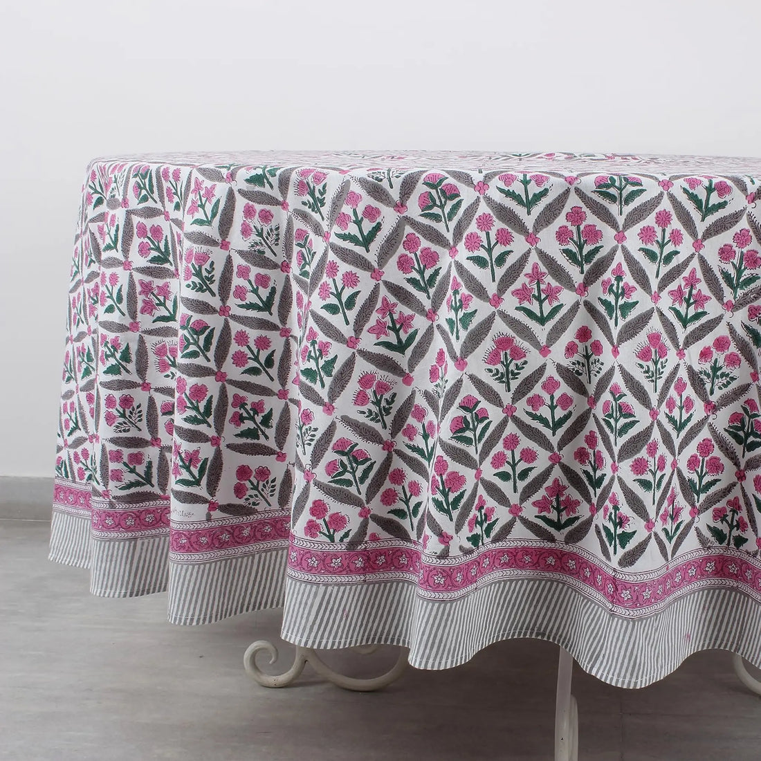 Floral patterned tablecloth on a wooden table with a white background
