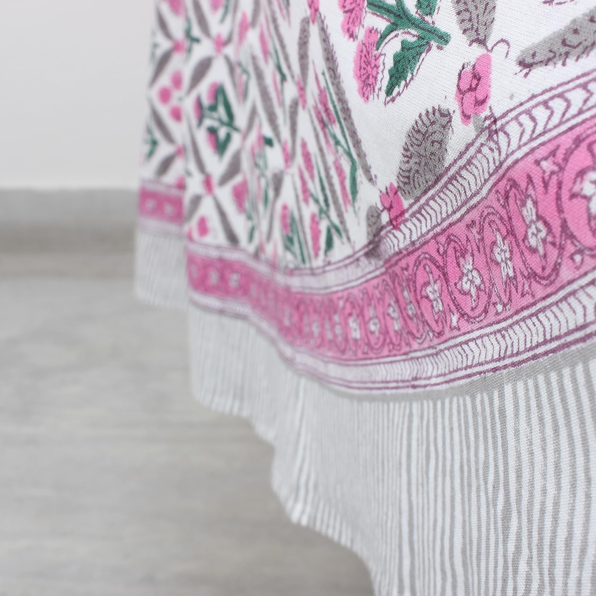 Close-up of a patterned fabric with pink and green design on a white background
