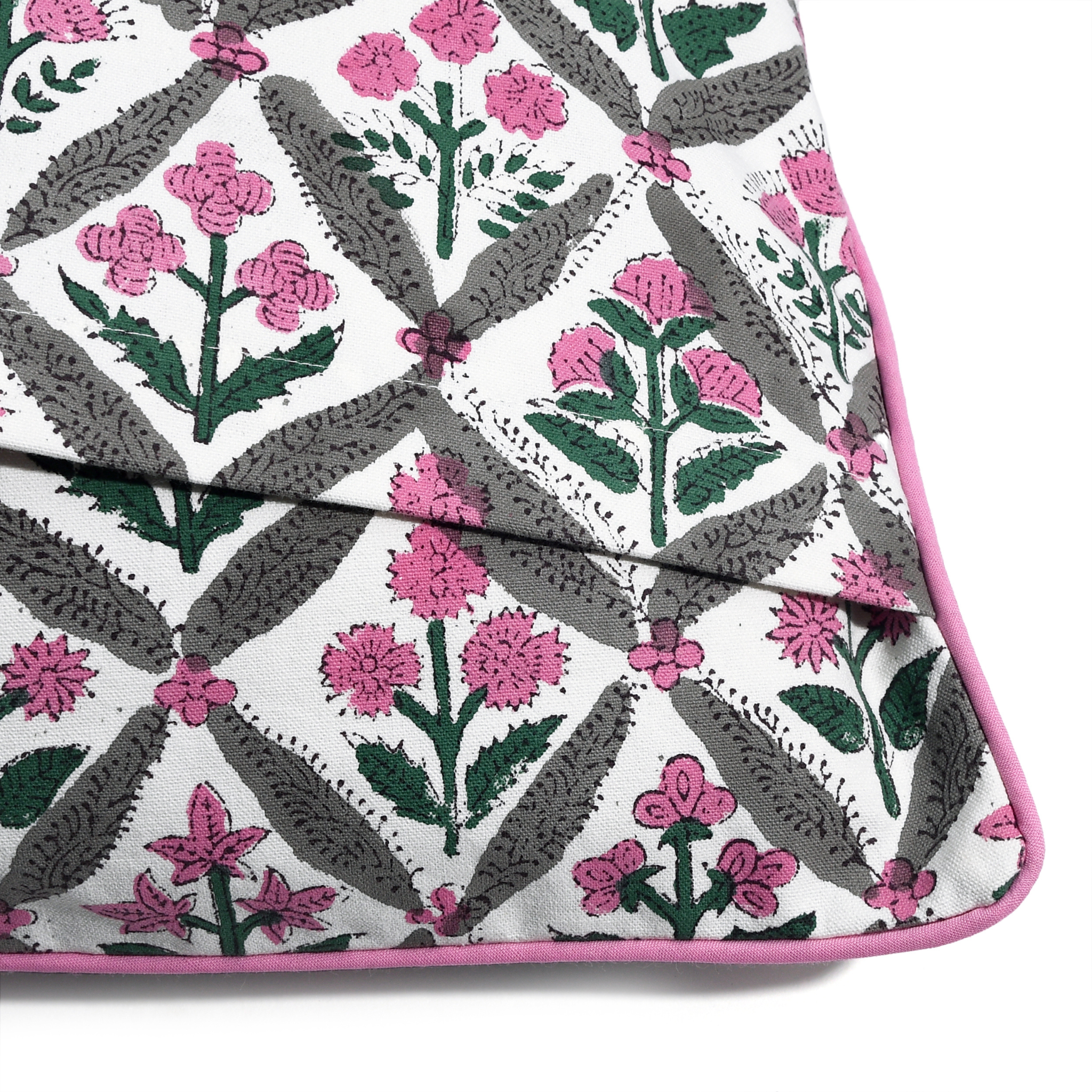 Floral patterned fabric with pink flowers and green leaves on a white background
