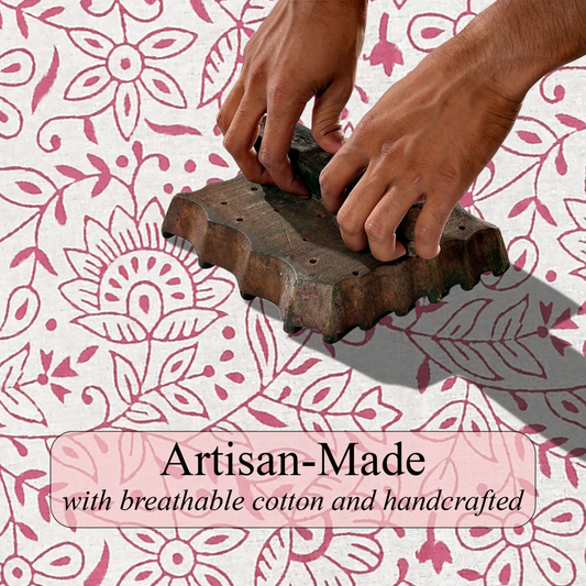 Person using a wooden block printing tool on fabric with floral pattern