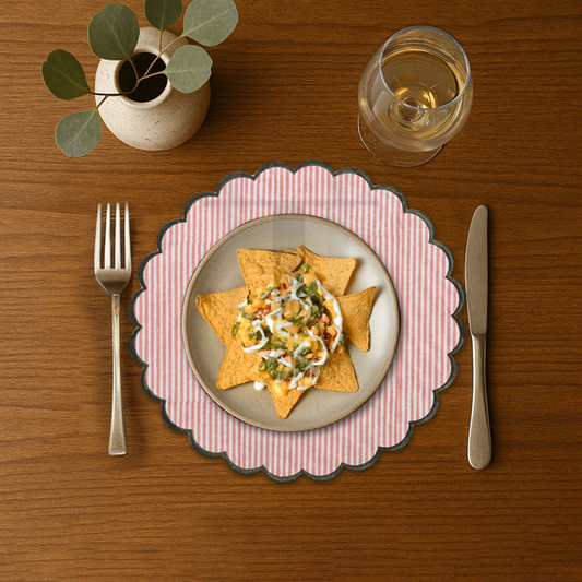 Dinner setting with a plate of food, fork, knife, and glass on a wooden table.
