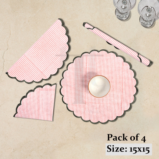 Pack of four pink and white patterned placemats on a beige surface.