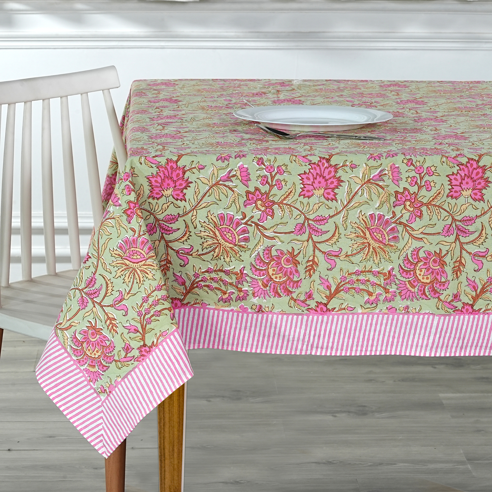 Floral tablecloth with pink and green pattern on a wooden table