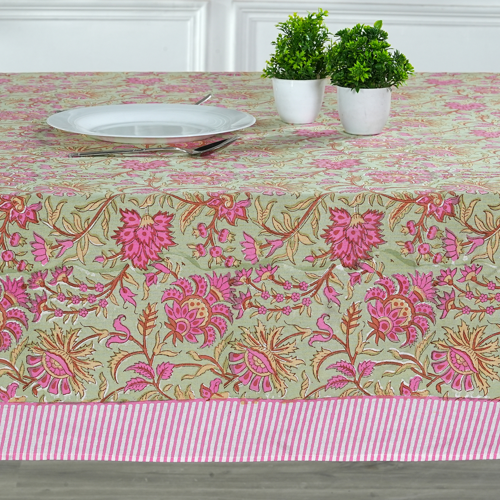 Floral patterned tablecloth with pink and green colors on a table setting.