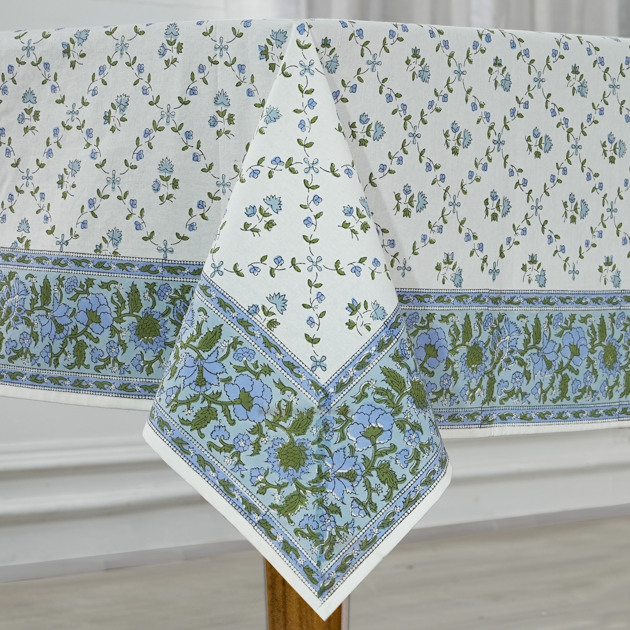 Floral patterned tablecloth on a wooden table with a white background