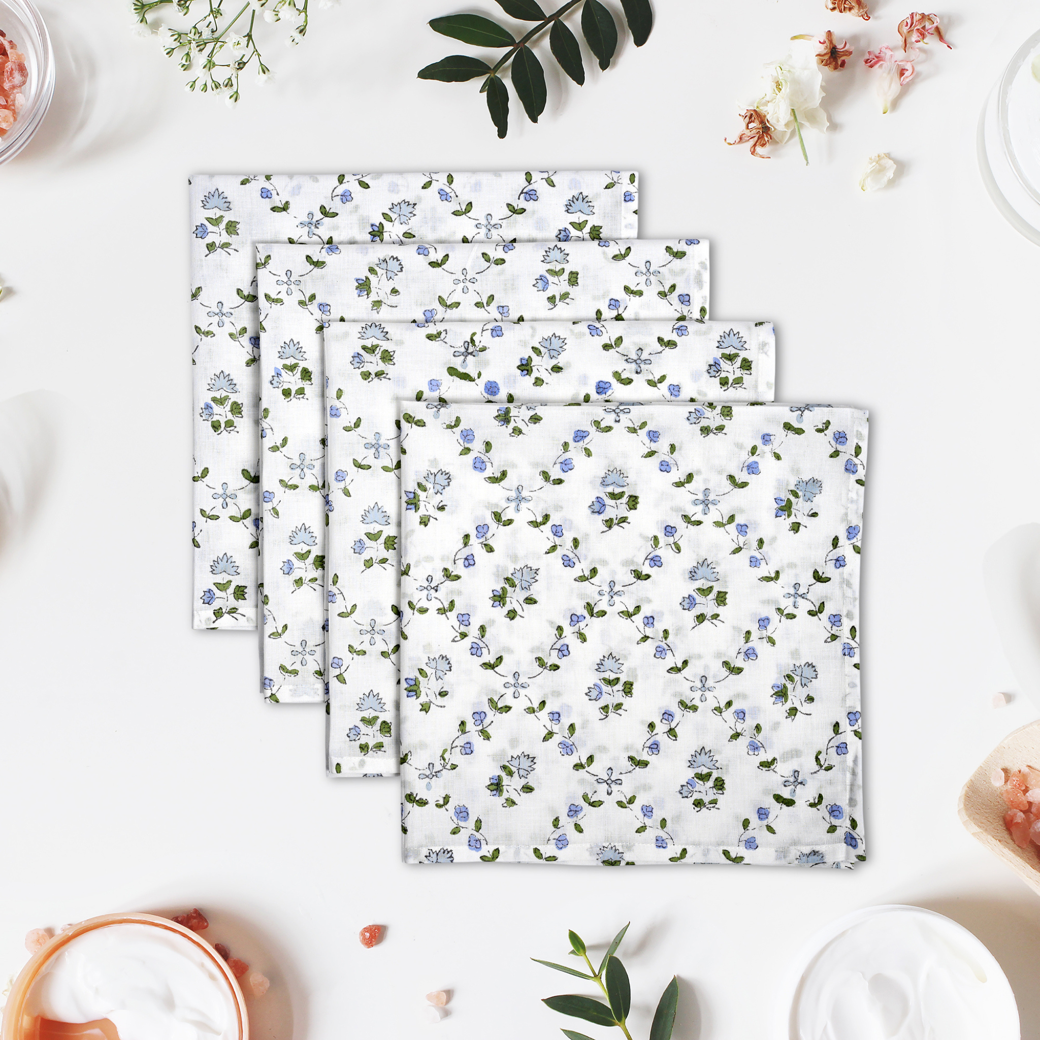 Set of floral-patterned napkins on a white surface with decorative elements.