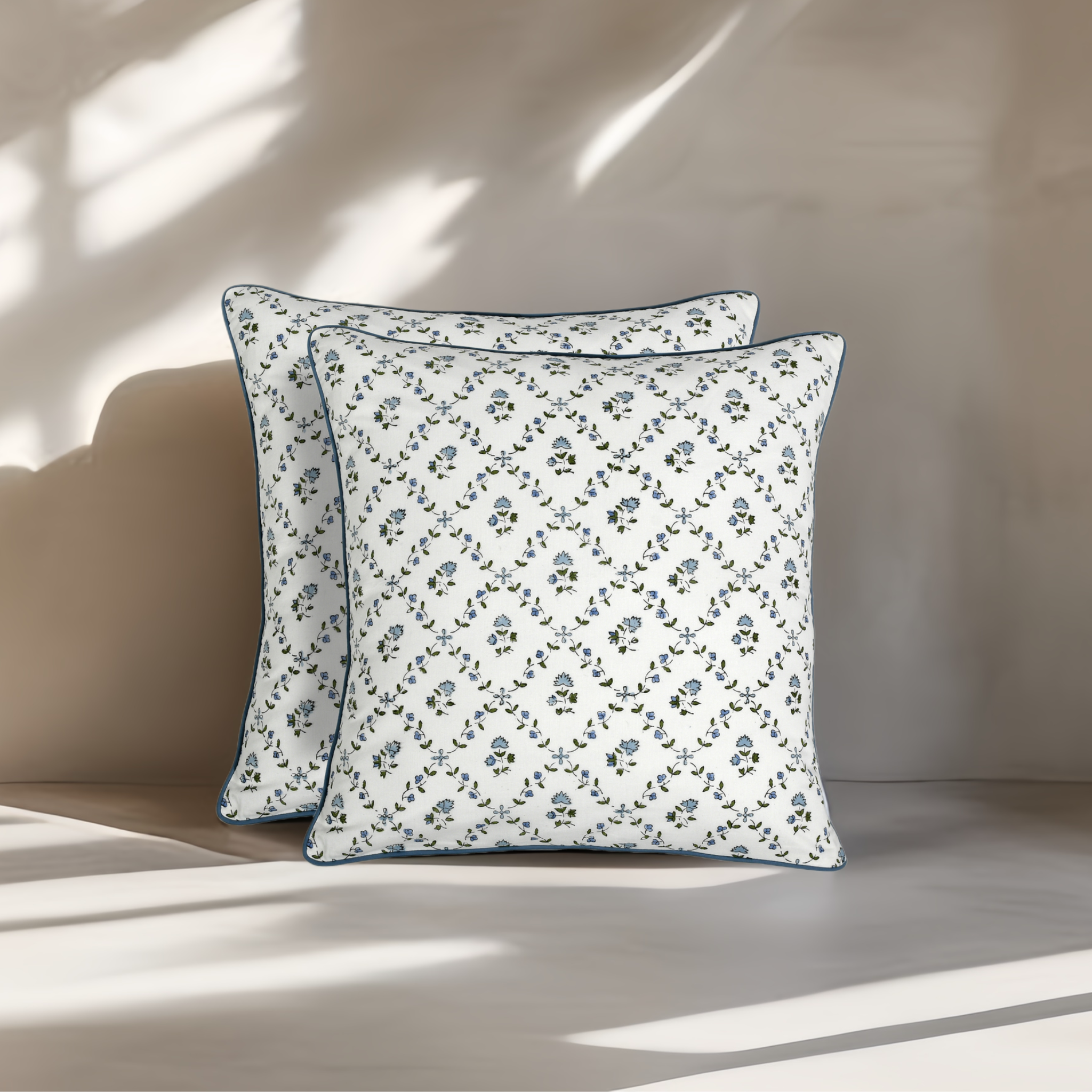 Two floral-patterned pillows on a neutral background