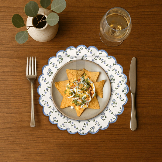 Dinner setting with a plate of food, fork, knife, and glass on a wooden table.