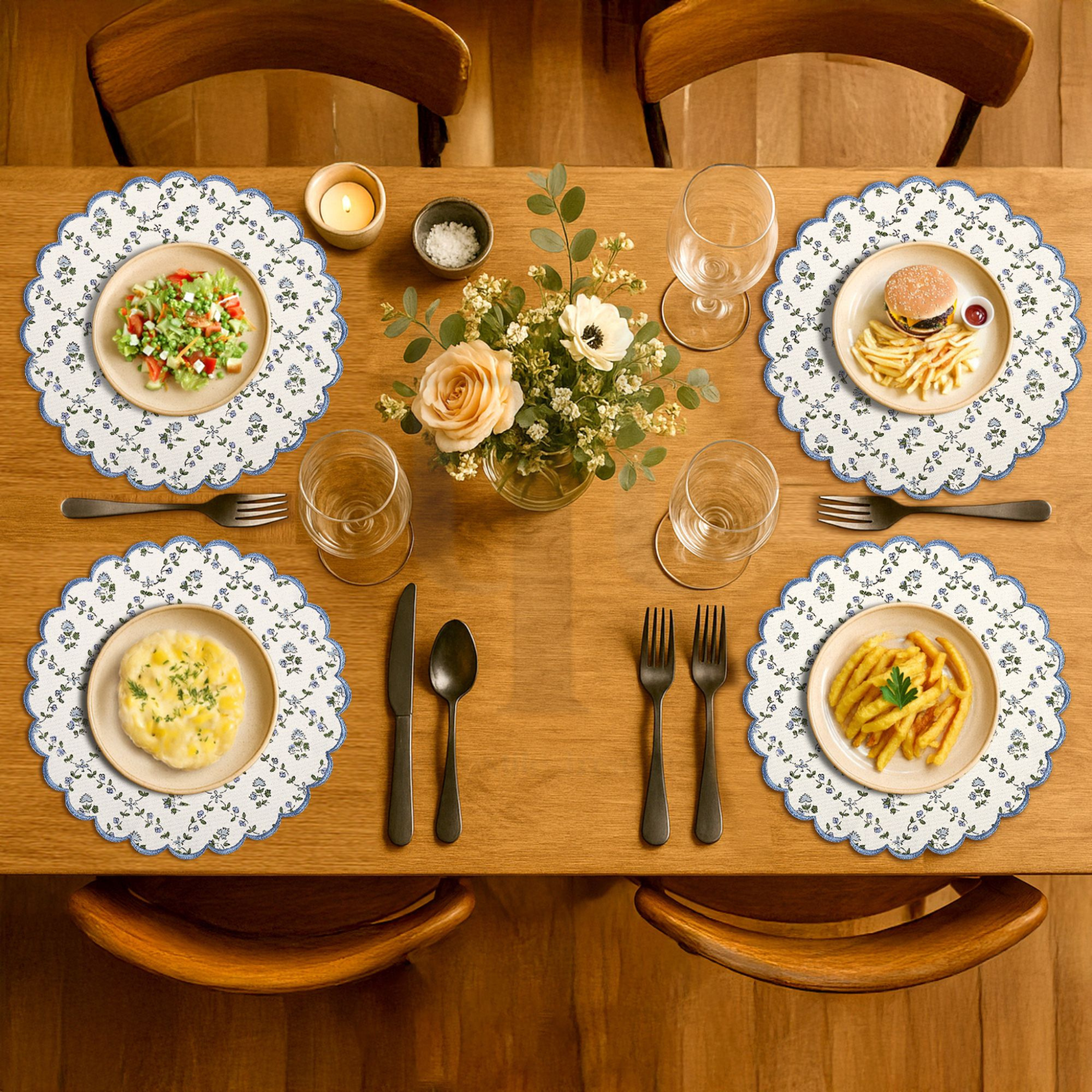 Dining table set with plates of food, glasses, and a floral centerpiece.