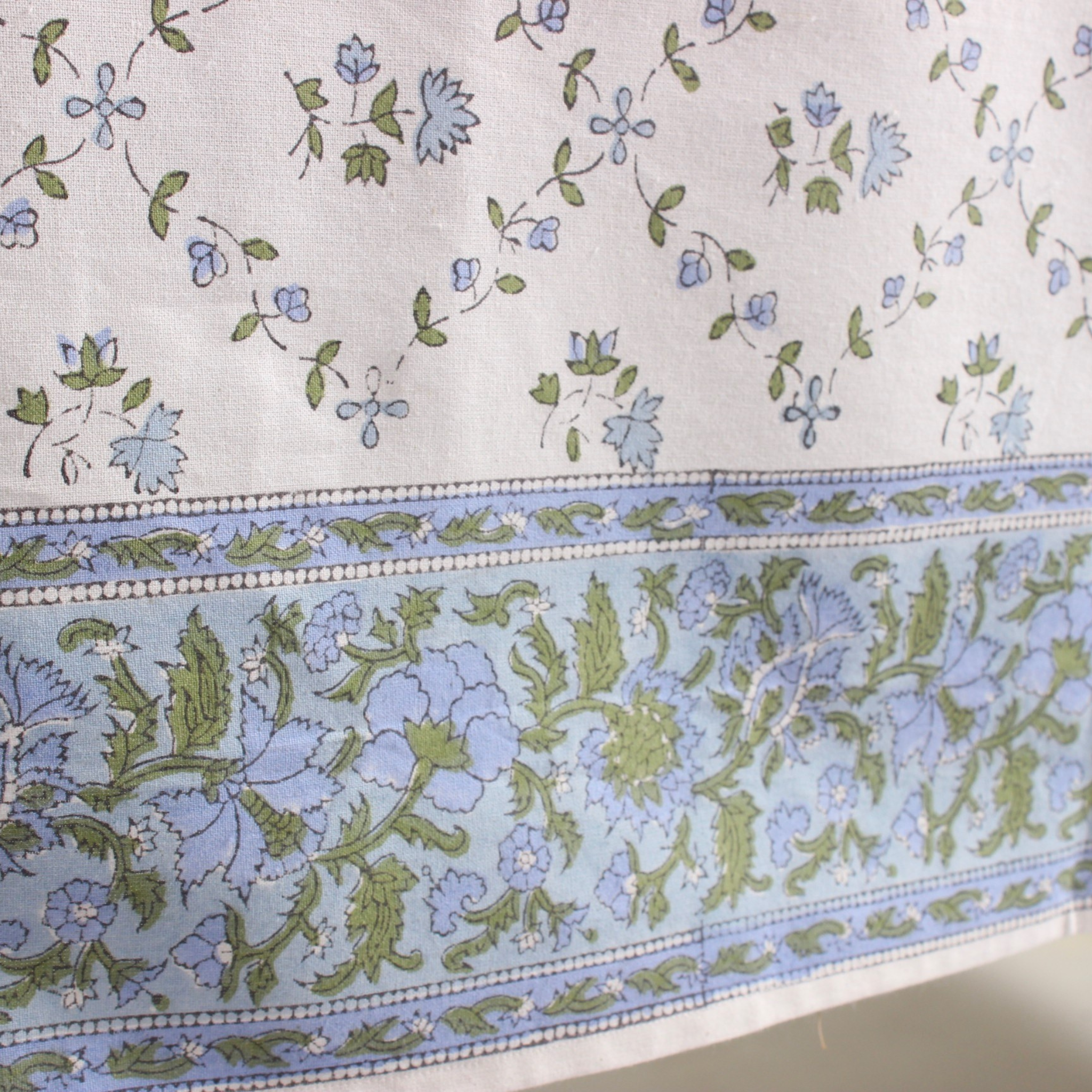 Floral patterned fabric with blue and green colors on a white background