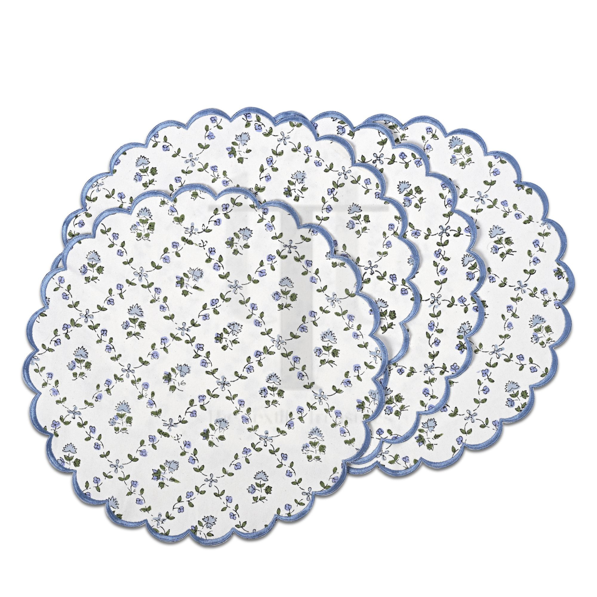 Set of three floral-patterned placemats with scalloped edges on a white background