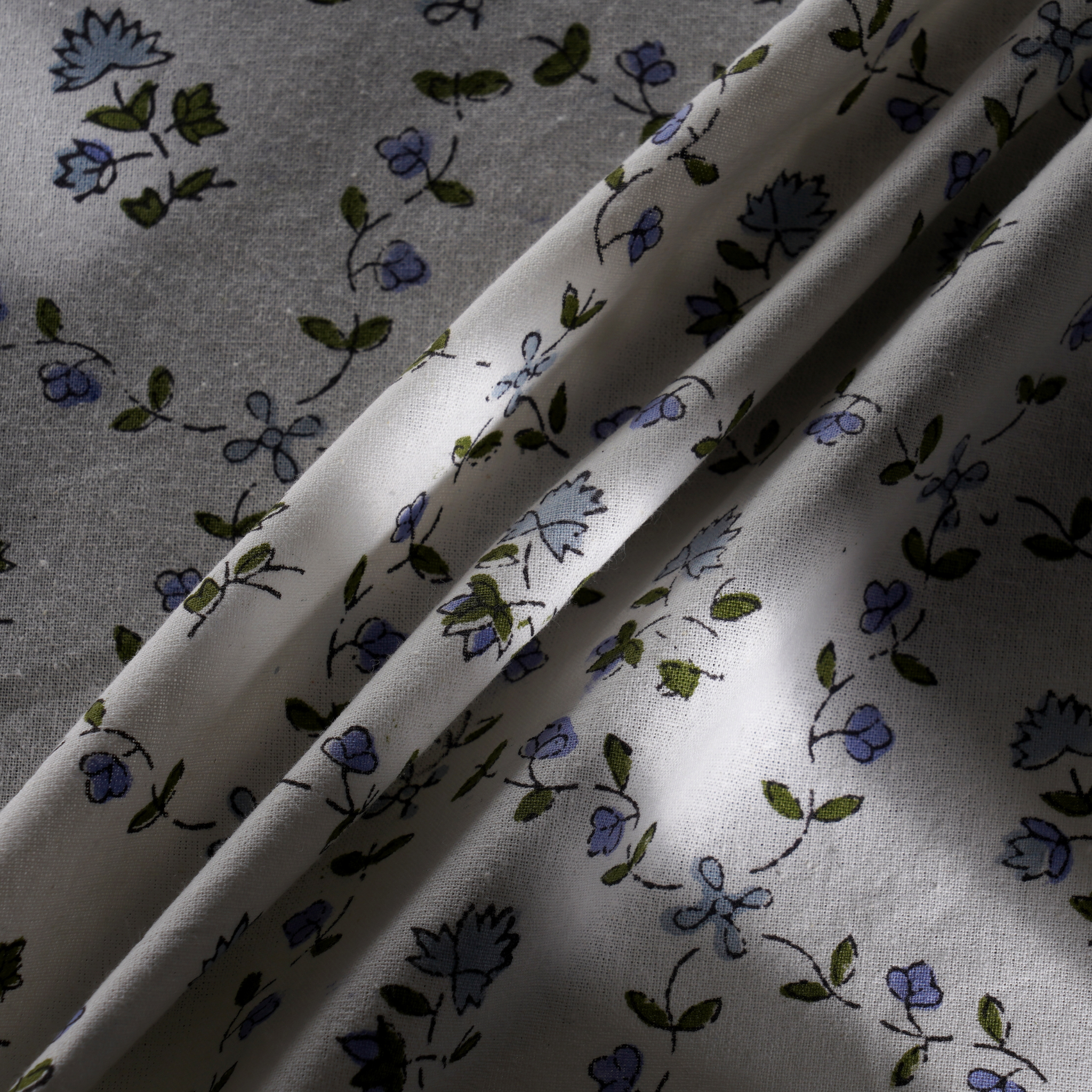 Floral patterned fabric with blue and green flowers on a white background
