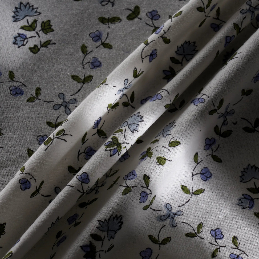 Floral patterned fabric with blue and green flowers on a white background