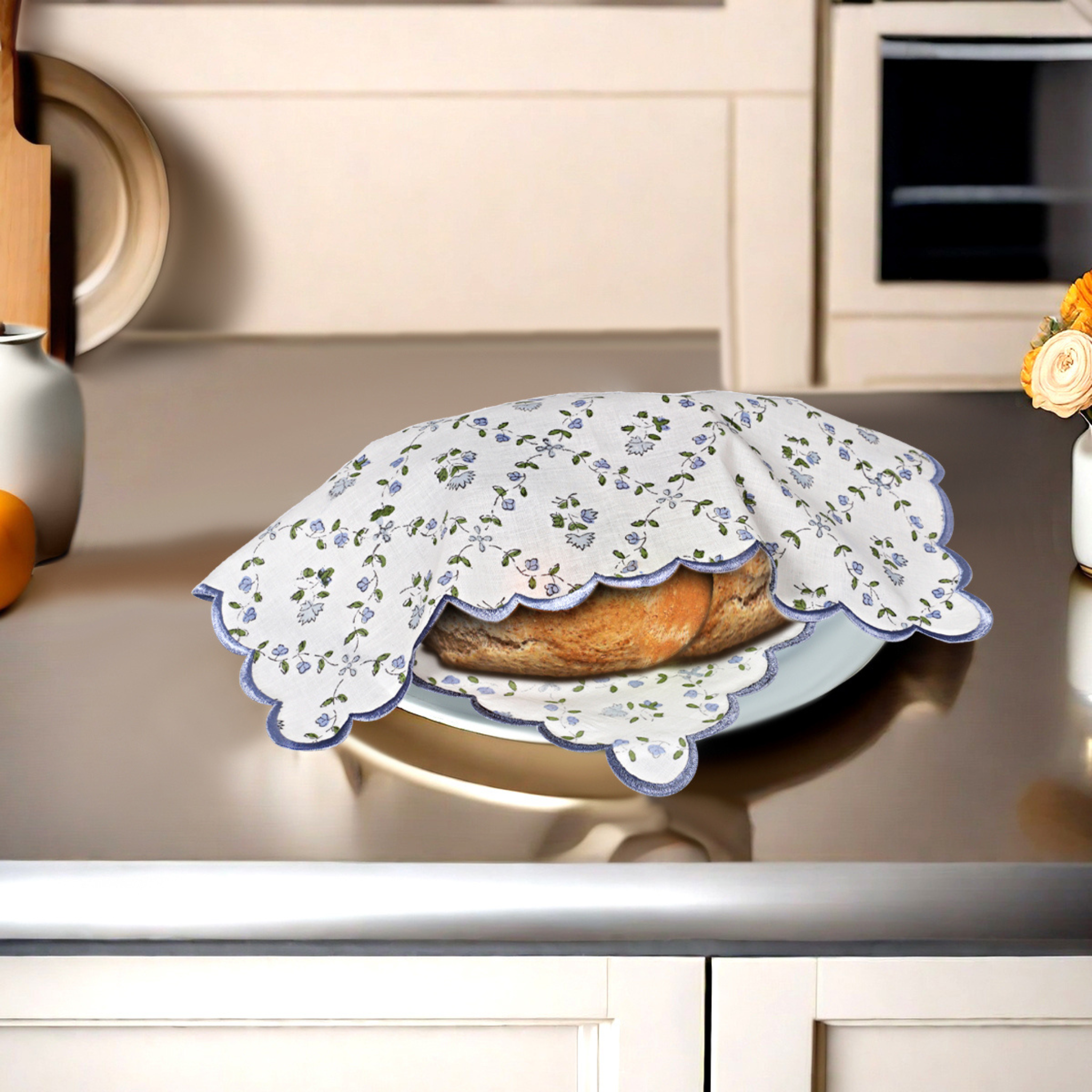 Floral-patterned cloth covering a dish on a kitchen counter.