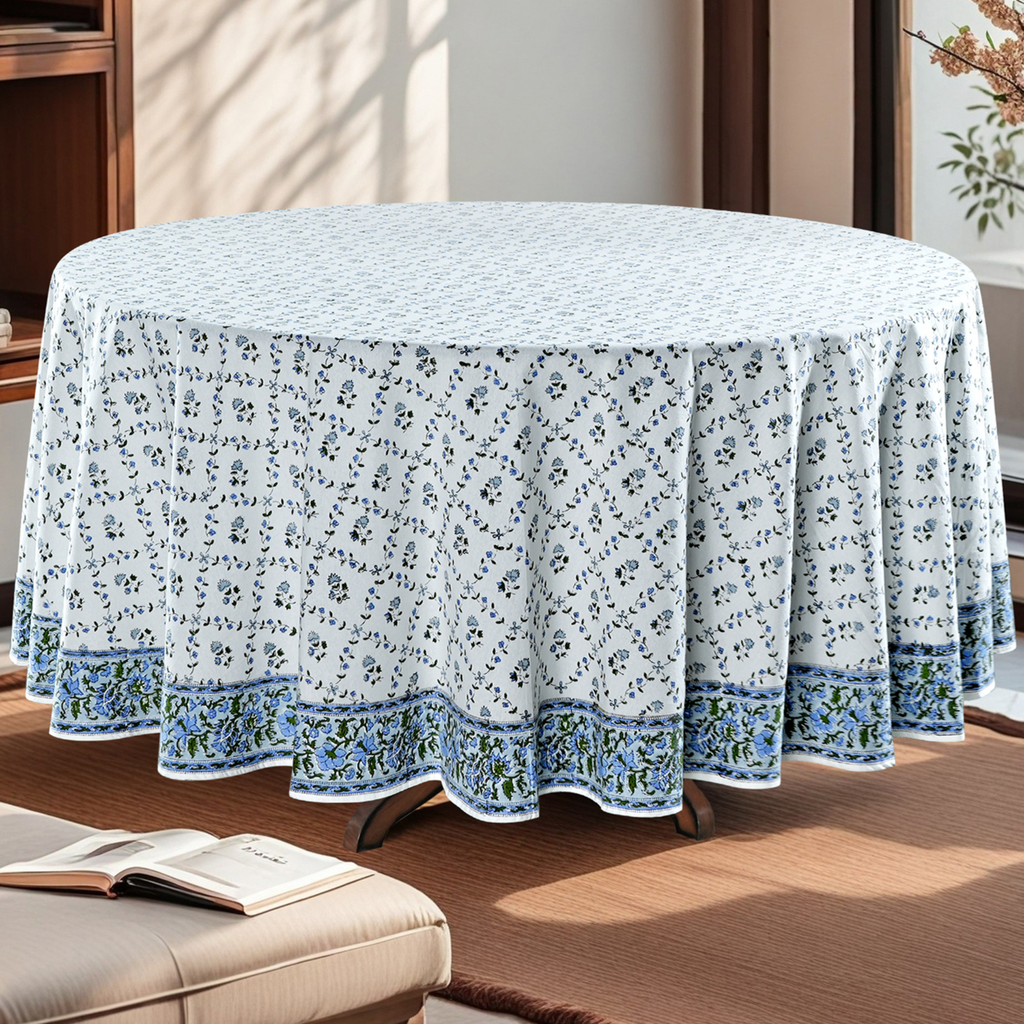 Round table covered with a floral tablecloth in a room setting.