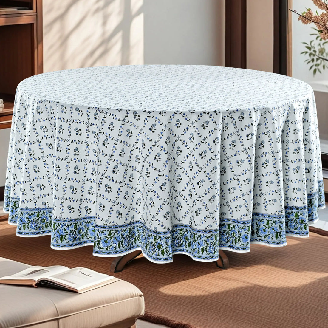 Round table covered with a floral tablecloth in a room setting.