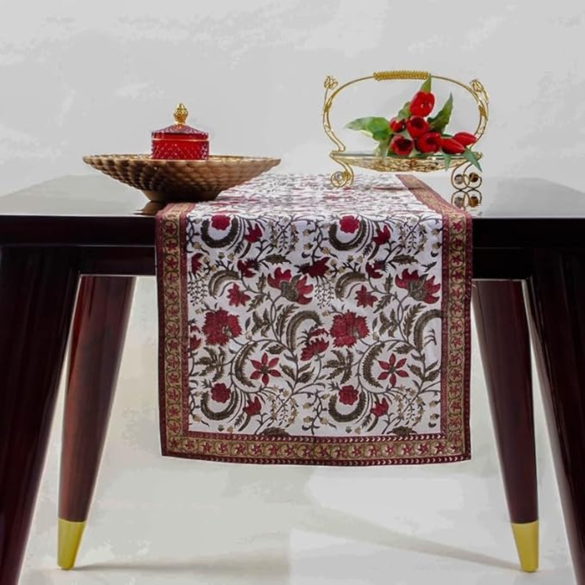 Decorative table runner with floral pattern on a wooden table.
